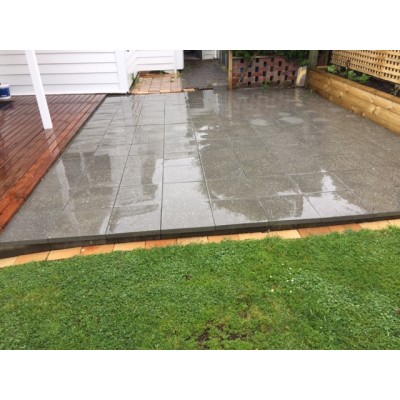 Exposed aggregate concrete paving slabs laid in a residential backyard