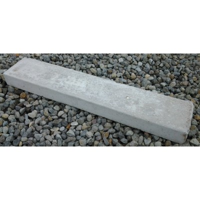 Rectangular concrete lawn edging strip on gravel